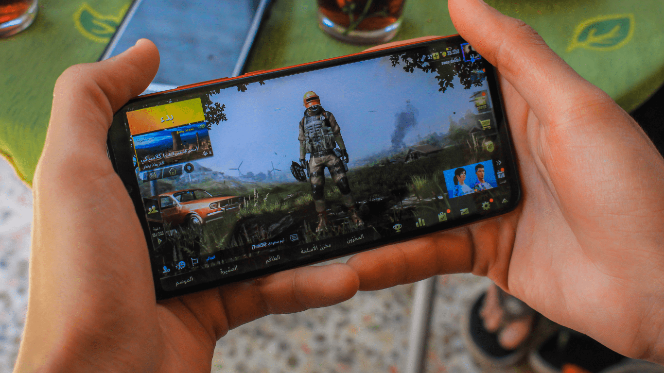 a person holding up a smartphone with a video game on it