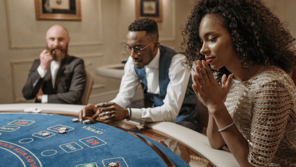 Two individuals in suits playing blackjack at a casino table.