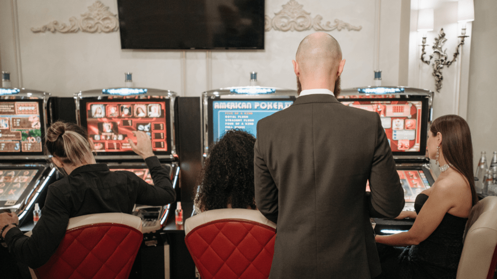 a group of people playing slot machines in a casino