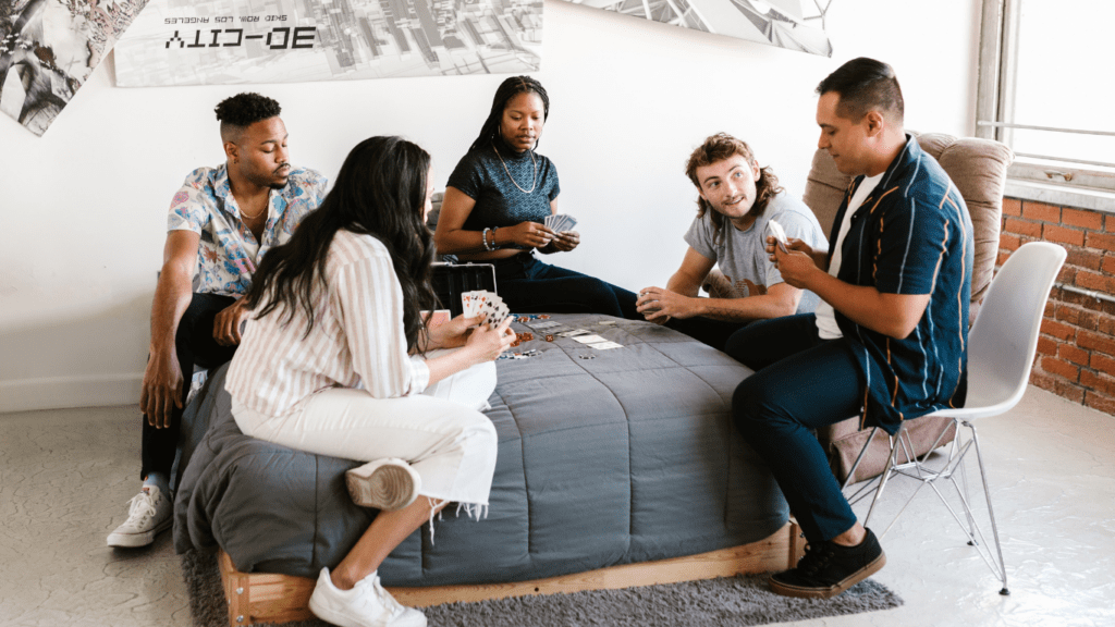 a group of people sitting on a bed with a laptop