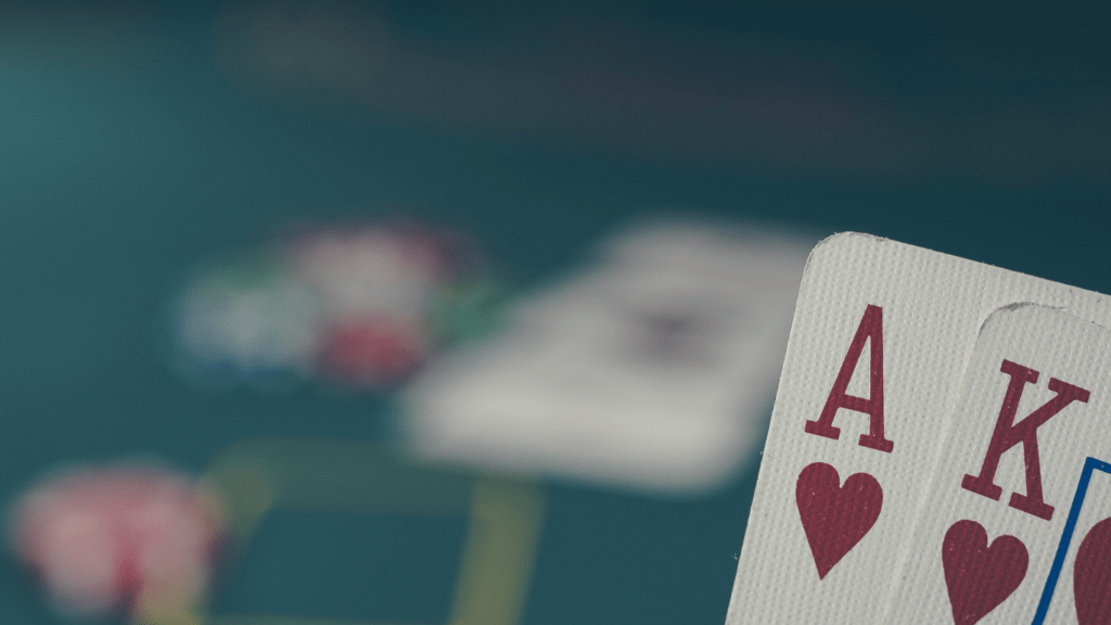 a hand holding a pair of playing cards