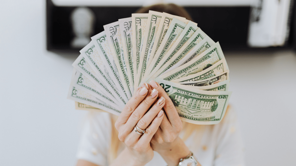 a person holding a bundle of currency