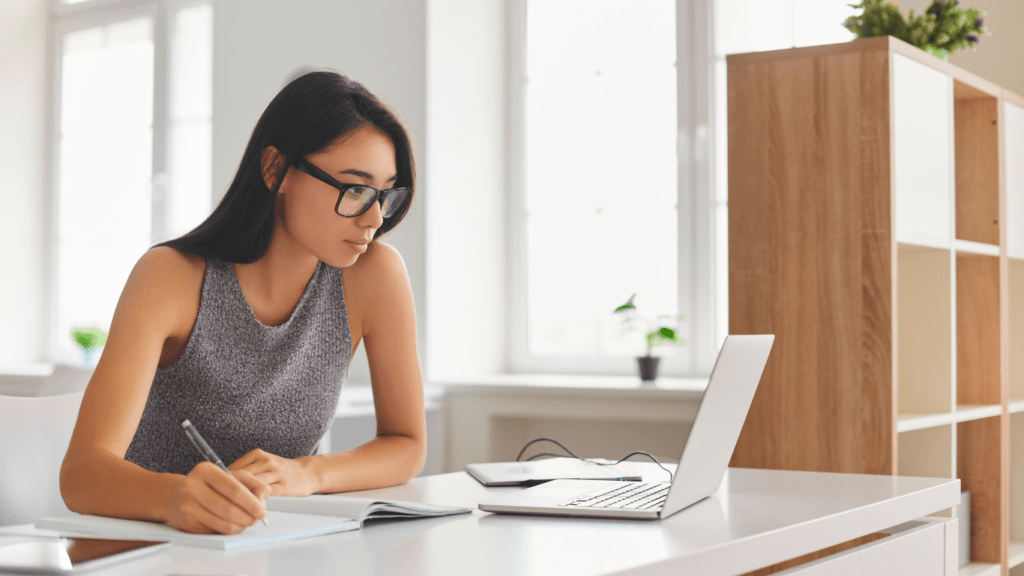 a person is sitting at a desk with a laptop