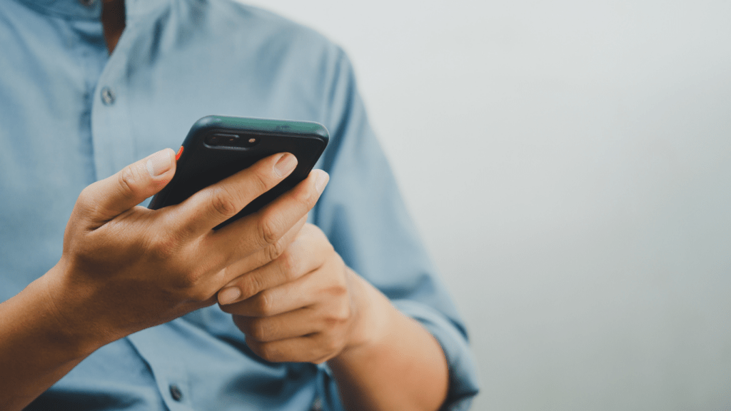 a person is using their phone while sitting in a chair