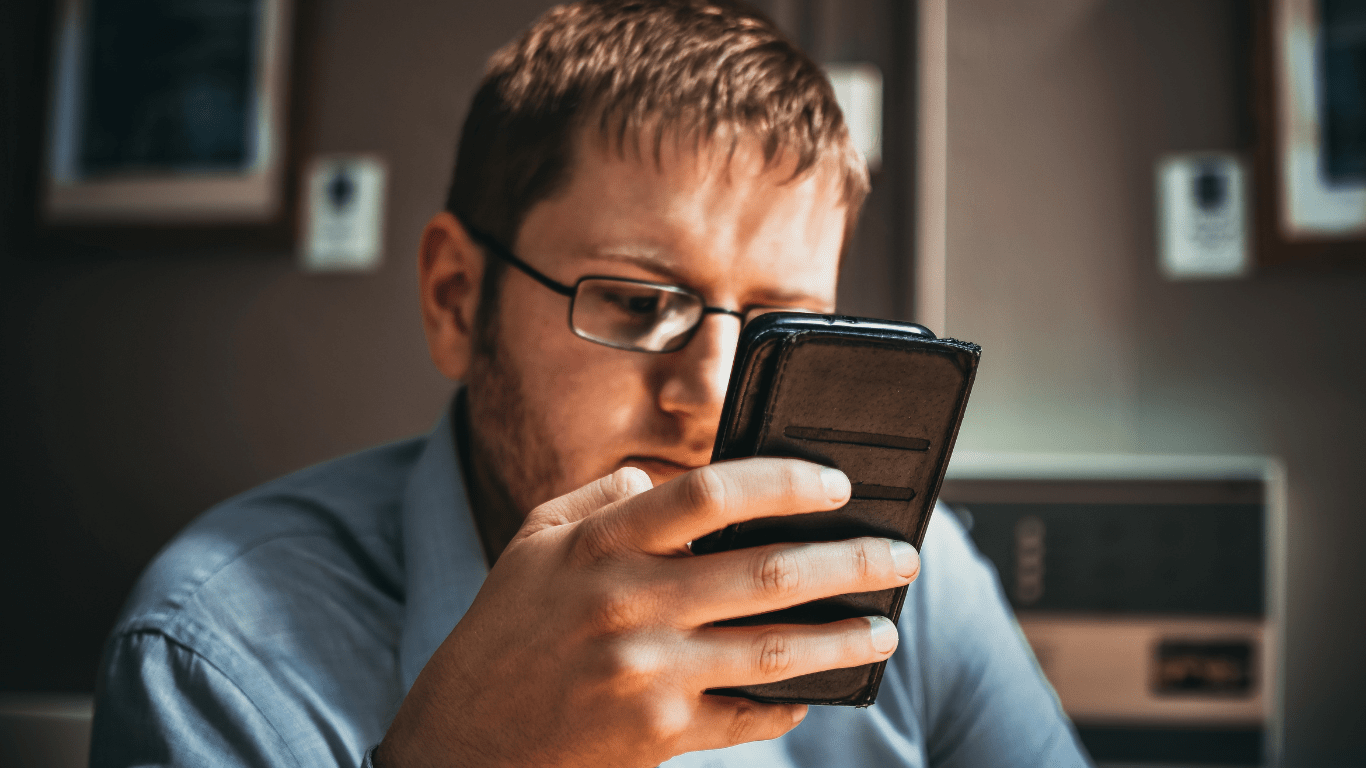 a person sitting on a couch looking at their phone