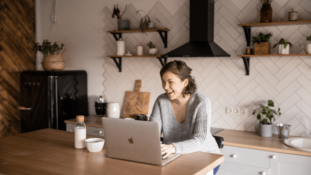 a person typing on a laptop with a cup of coffee next to it