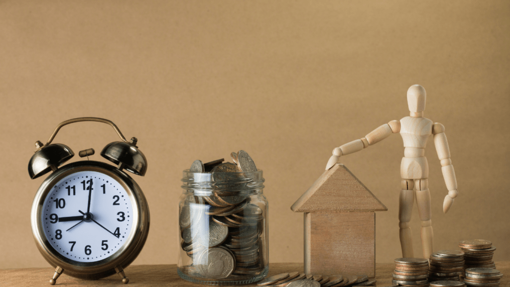 an alarm clock and stacks of coins on a table