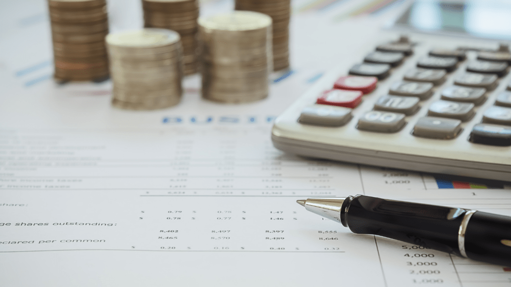 calculator, coins and pen on financial documents